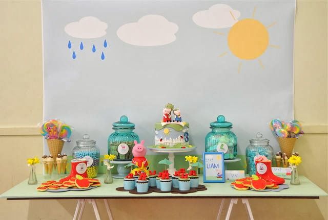 Mesa decorada para festa Peppa Pig com docinhos e enfeites