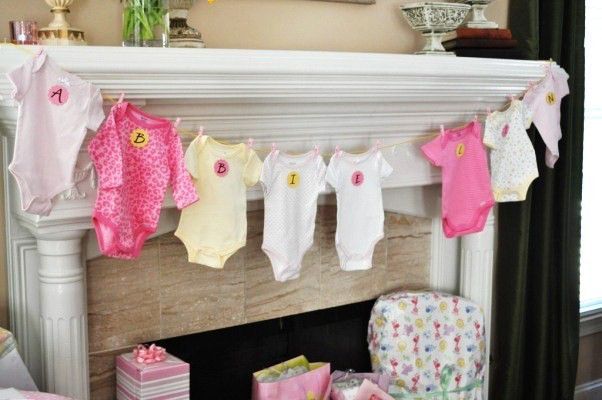 varal de roupinhas de bebê como painel de fundo do chá