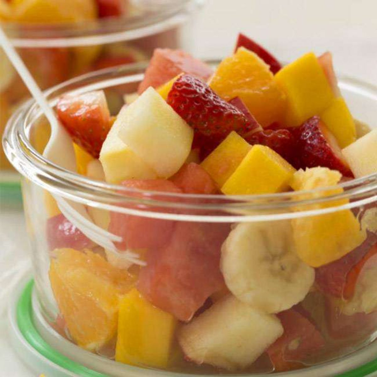 Mesa com opções variadas como salada de frutas, pasteizinhos e doces no pote