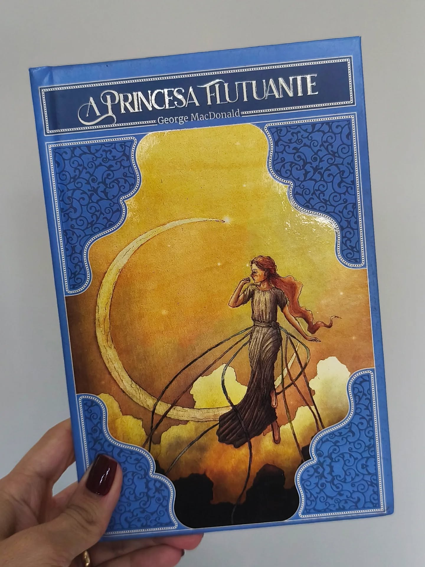 Livro A Princesa Flutuante de George MacDonald, capa azul com ilustração de princesa, edição encantadora